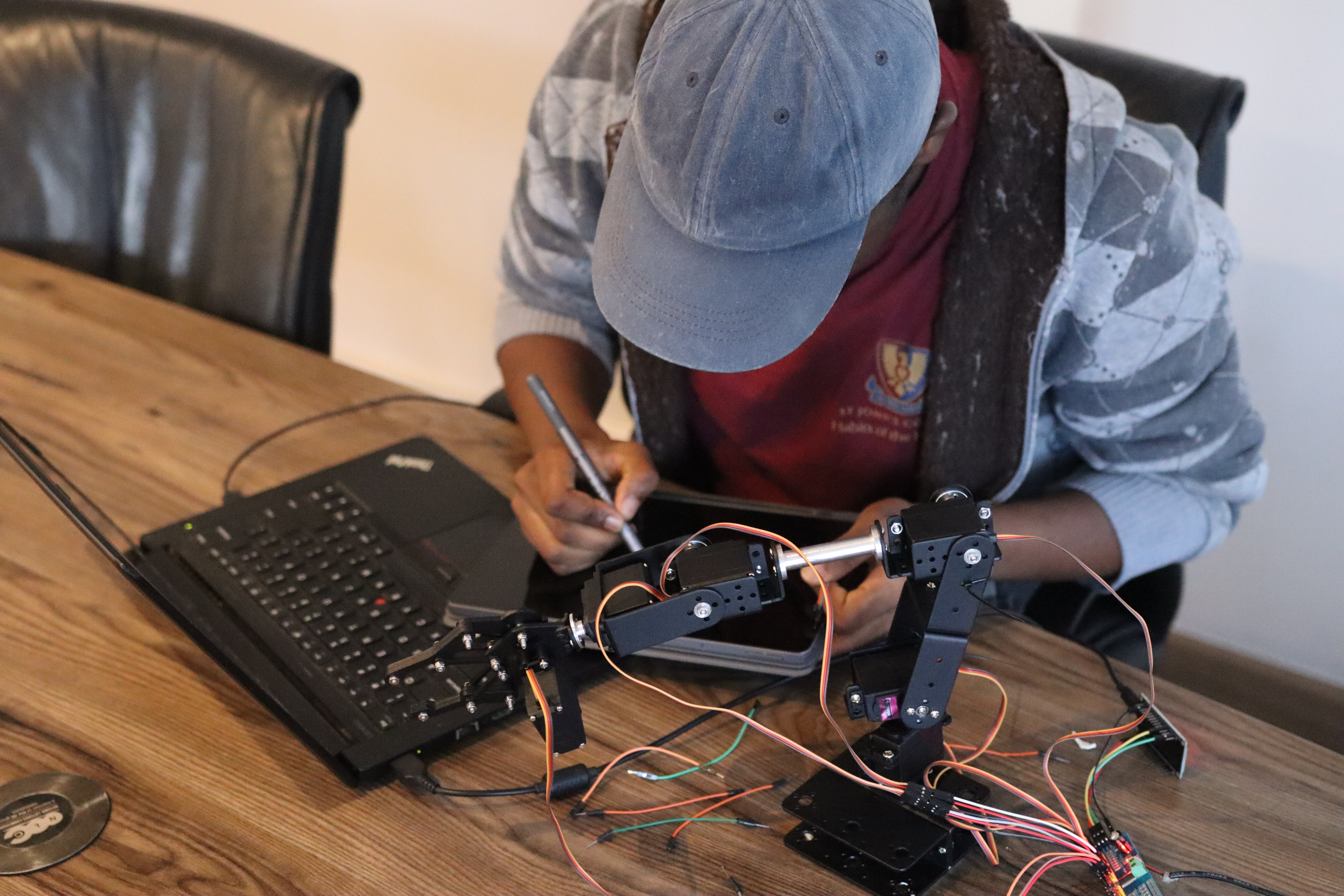 Student programming a robotic arm